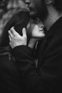 a black and white photo of a man and woman hugging