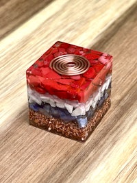 a red, white and blue glass cube on a wooden table