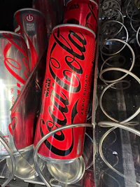 a can of coca cola sitting on a shelf