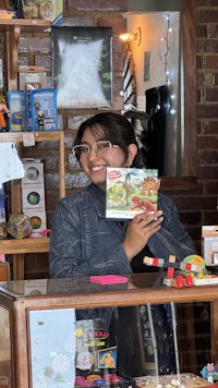 a woman holding a book in front of a store
