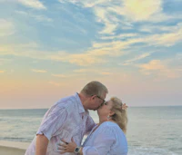 a couple kissing on the beach at sunset