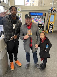 three people posing for a picture in an airport