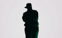 a silhouette of a man in a green hat