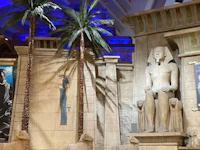 an egyptian museum with statues and palm trees