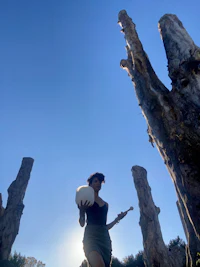 a woman holding a frisbee in front of a tree