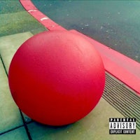 a red ball sitting on the side of the road