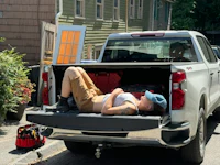 a woman laying in the back of a pickup truck