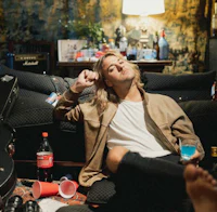 a man sitting on a couch with a bottle of coca cola