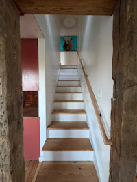 a staircase leading to a room with a painting on the wall