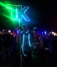 two people posing with a sign that says tk