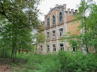 an abandoned building in the middle of a forest