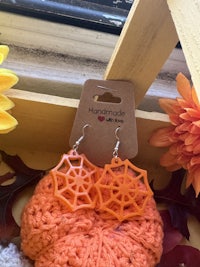 orange spider web earrings in a wooden box