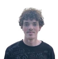 a young man with curly hair standing in front of a white background