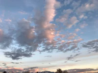 sunset over a mountain range with clouds in the sky