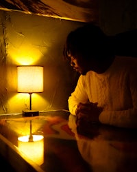 a man leaning against a table in a dark room