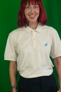 a woman wearing a white polo shirt and black pants