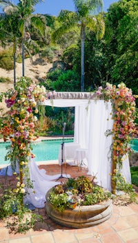 a wedding ceremony set up in front of a pool