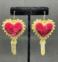 a pair of pink heart shaped earrings with crystals