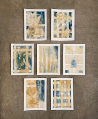 six blue and yellow ink prints on a concrete floor