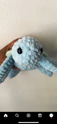 a blue stuffed toy is being held up by someone