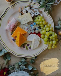 a plate of cheese with grapes and grapes on it