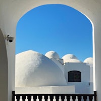 a view of a white building with domes in the background