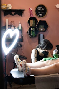 a woman getting tattooed in a tattoo shop