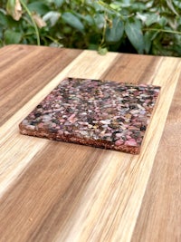 a pink and brown stone coaster on a wooden table