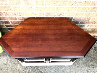 an octagonal coffee table in front of a brick wall