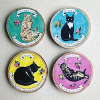 four wooden coasters with cats on them