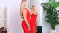a woman in a red dress is standing in front of a mirror