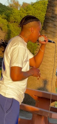 a man singing into a microphone at a park