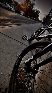 a black bike parked on a sidewalk