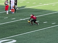 a woman is catching a ball on a field