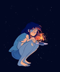 a girl sitting on the ground with a candle in her hand