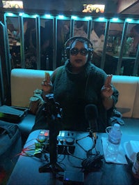 a woman is sitting at a table in front of a microphone