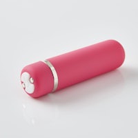 a pink cylinder with a silver lid on a white surface