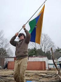 a man holding a flag in front of a construction site