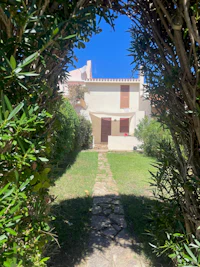 a pathway leading to a house in a green area