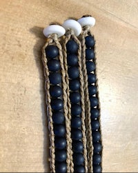 a pair of black and white beaded bracelets on a wooden table