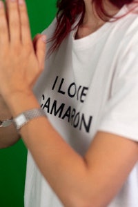 a woman wearing a white t - shirt that says i love camon