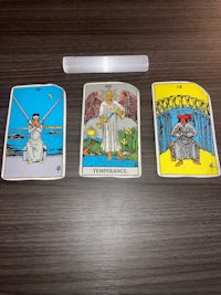 three tarot cards on a table