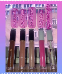 four lip glosses in different colors on top of a table