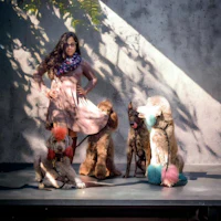 a woman is posing with a group of dogs