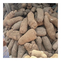 a man is standing next to a pile of potatoes