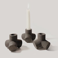 three concrete candle holders with a candle in the middle
