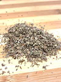 a pile of dried herbs on a wooden table