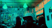 a man in a hat is standing in front of a green light
