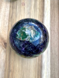 an amethyst sphere on a wooden table
