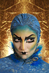 a woman with blue feathers and makeup on her face